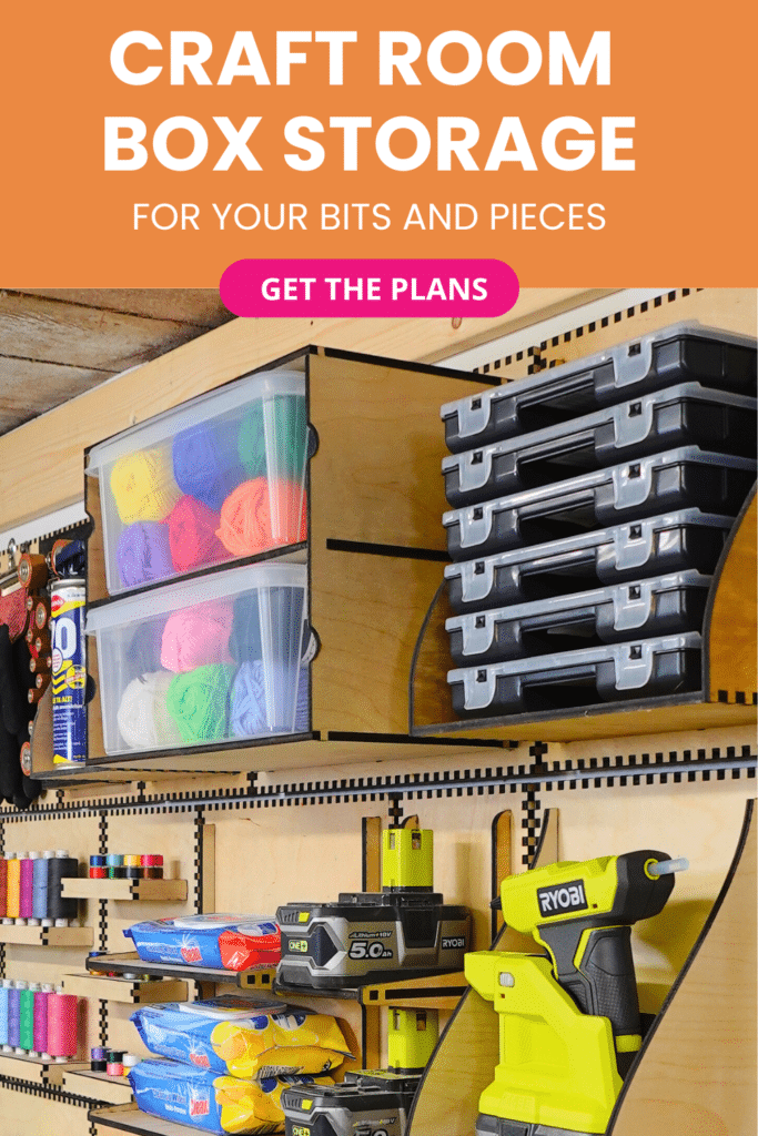Laser‑cut plywood French cleat box storage on a craft room wall, holding clear tubs of colourful yarn, stacked black organiser cases, thread racks and a yellow cordless glue gun with batteries.
