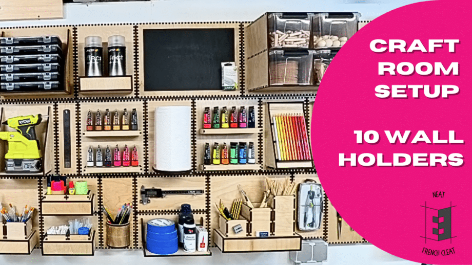Wide craft wall setup with multiple laser-cut French cleat holders on a plywood wall, storing paints, brushes, tools, boxes and a paper towel roll, with a pink circle overlay reading “Craft Room Setup – 10 Wall Holders.”