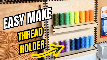 YouTube thumbnail showing a laser‑cut plywood French cleat thread holder on a wall, with two rows of colourful thread spools and bold text reading “Easy Make Thread Holder” with a yellow arrow pointing at the holder.