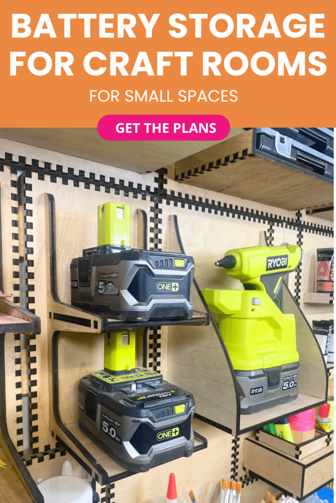 Laser-cut French cleat battery holder on a plywood wall, shown at an angle with stacked Ryobi cordless tool batteries and a matching cordless hot glue gun stored on open shelves.