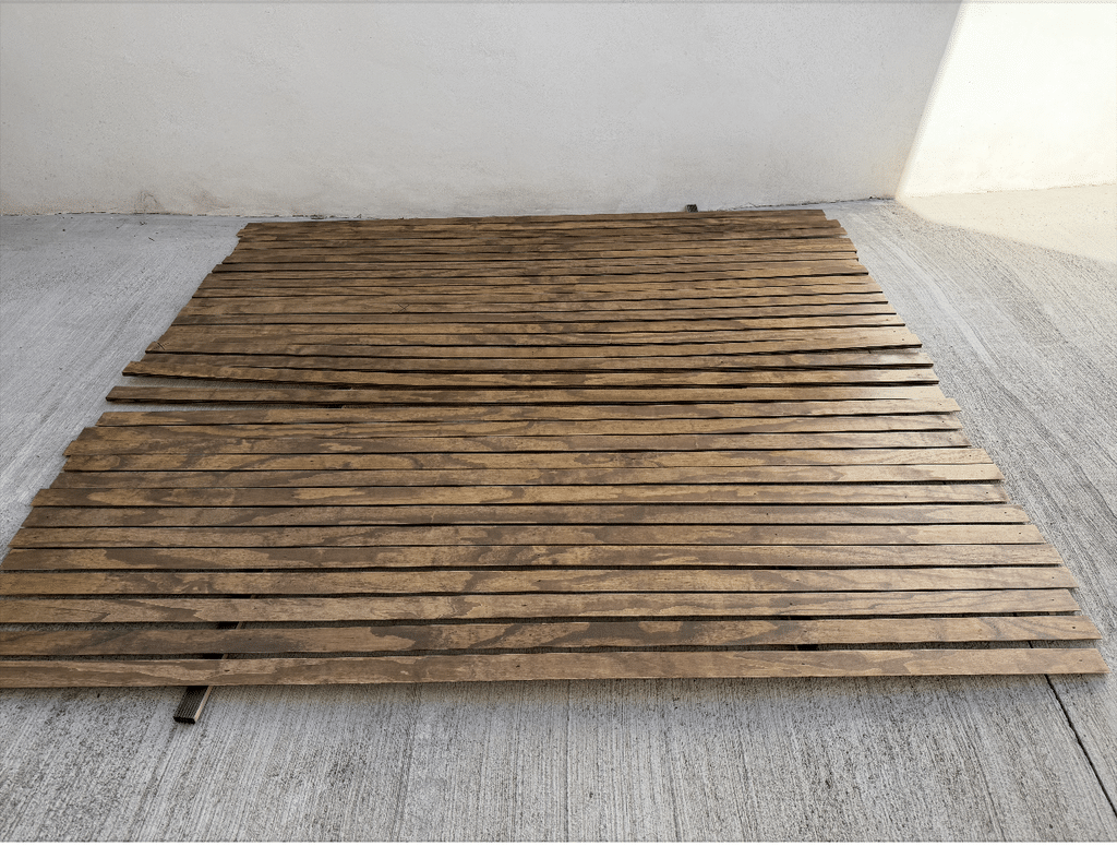 Gavin's French Cleat wall cleats, varnished wood strips and laid flat outdoors to finish drying before being mounted to the wall.
